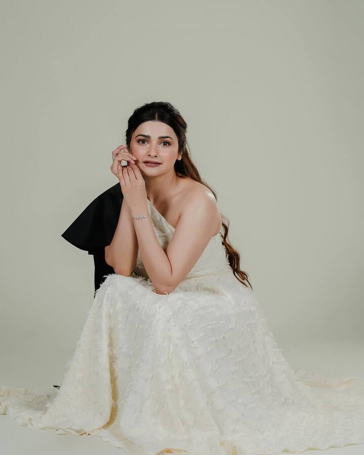 Prachi is looking very graceful in this picture. She is wearing an off-shoulder white gown, with a texcharged design and black detailing touch. Nude makeup, open hair and minimal jewelery are making their look even more classy.