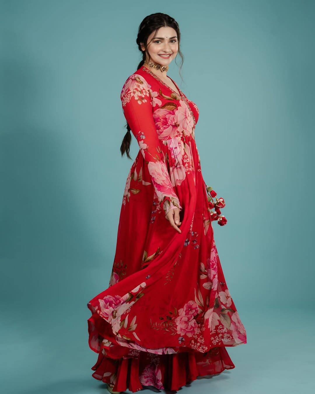 Prachi is looking very traditional and fresh in this look. She is wearing a red floral printed floi dress, which she has styled with simple makeup, open hair and bran necklace.