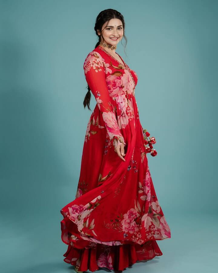 Prachi is looking very traditional and fresh in this look. She is wearing a red floral printed floi dress, which she has styled with simple makeup, open hair and bran necklace.