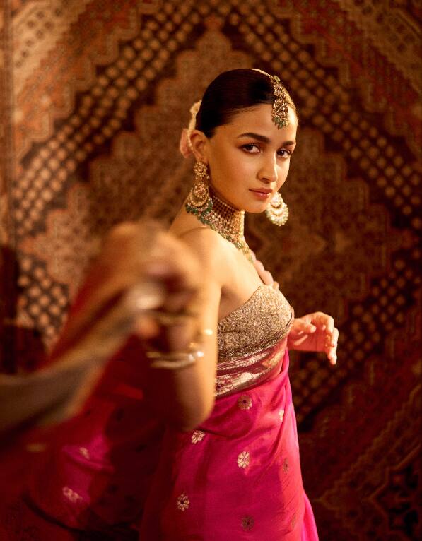 In this picture, Alia Bhatt is seen in a royal style in pink silk saree and heavy jewelery. His classy hair is making this royal look even more attractive.