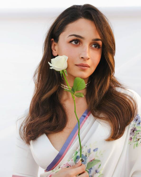 In this picture, Alia Bhatt is wearing a white flower saree and holding a white flower in his hand.