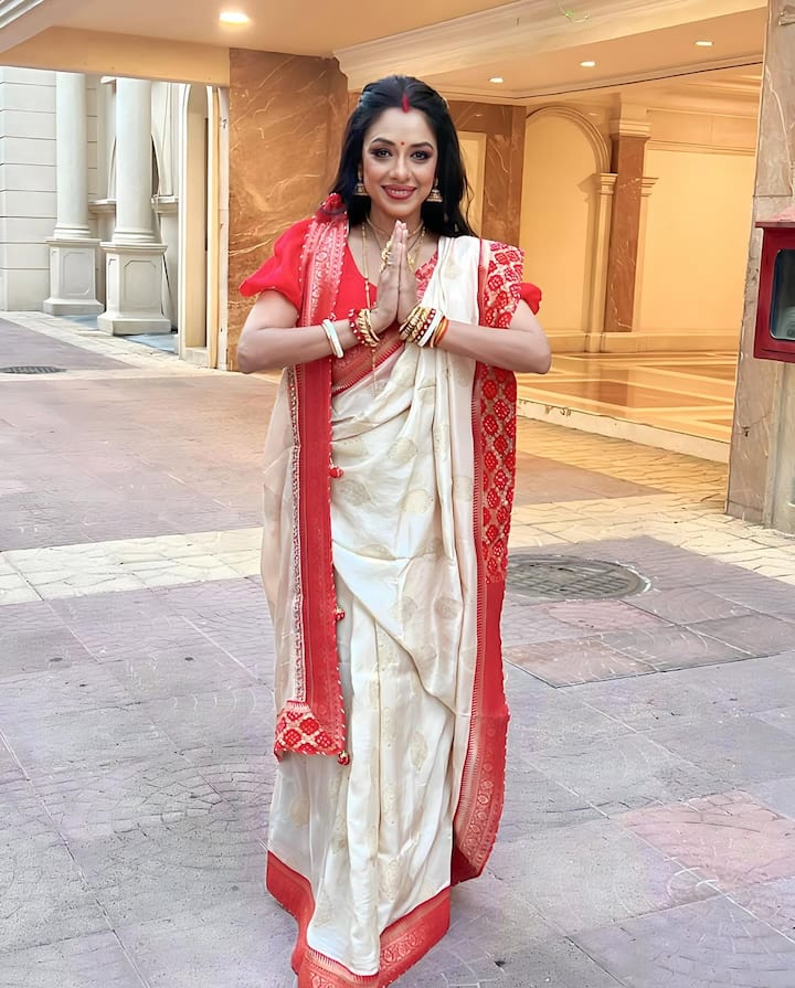 Rupali Ganguly is wearing an off-white silk saree in this look, which has a red border. He has styled it with red blouse, gold jewelery, bangles and big red bindi of foreheads. Sindoor and open hair are making their traditional Bengali Durga Puja look even more special.