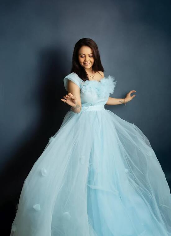 Devolina Baby looks like a princess in a blue gown. His smile and flowi dress is making her look very cute and driem.