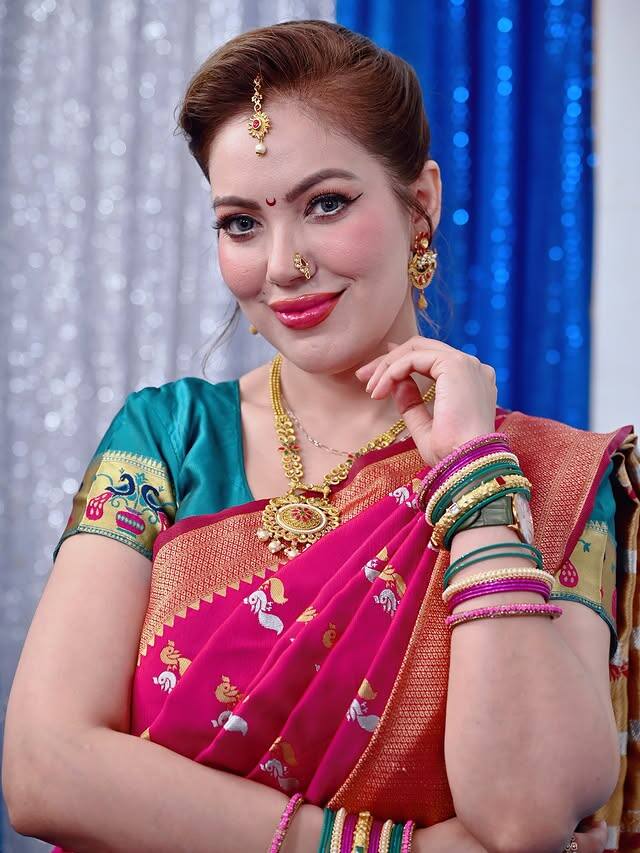 निळ्या रंगाचा रेशमी भरतकाम केलेला ब्लॉऊज तिच्या या लुक ला आणखी उठावदार बनवत आहे