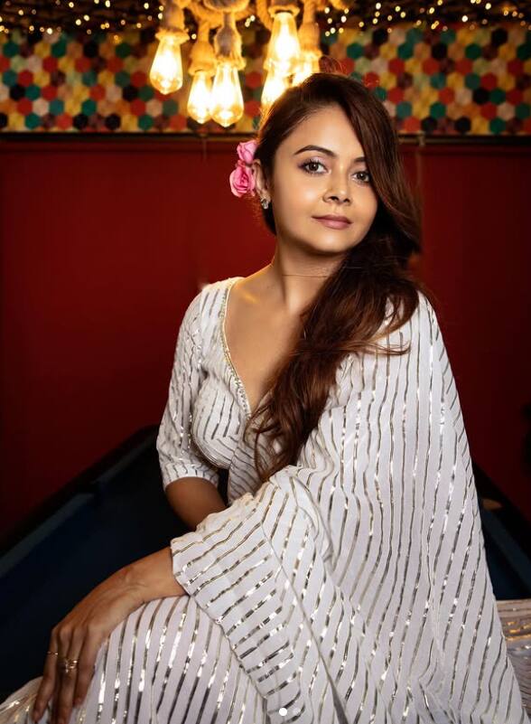 सफेद सिल्वर लाइनिंग वाली साड़ी में बेहद ग्रेसफुल नजर आ रही हैं. हेयरस्टाइल में लगाया गया गुलाबी फूल उनके लुक में ट्रेडिशनल चार्म जोड़ रहा है.