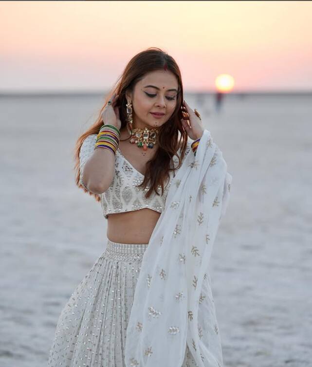 Devolina Bhattacharjee is seen in a traditional look in white lehenga. His simple and elegant style looks very beautiful with sunset view.