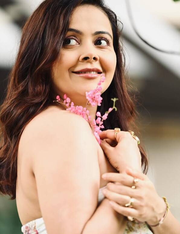 In this picture, Devolina Bhattacharjee is seen in a very natural and fresh look. She has given a cute smile with light makeup and pink flowers in her hands with open hair.