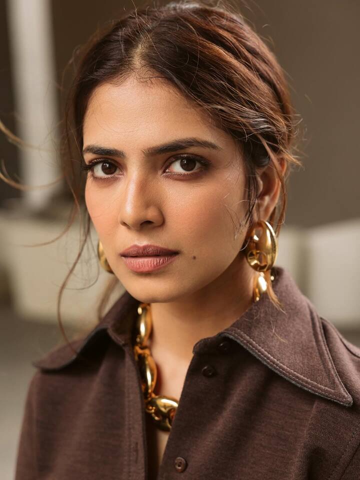 Her hair, styled in a messy middle-parted low ponytail, added an effortless charm to the outfit.