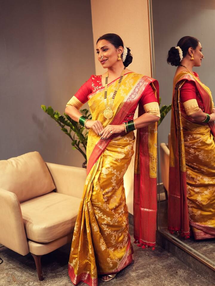 तिने पिवळ्या रंगाची लाल बॉर्डर असलेली सुंदर साडी परिधान केली आहे.
