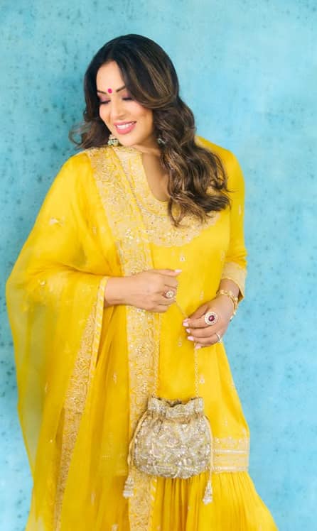 इस तस्वीर में बिपाशा बसु पीले रंग के ट्रेडिशनल सूट में बेहद खूबसूरत लग रही हैं. उनकी मुस्कान और स्टाइलिश अंदाज़ तस्वीर को और भी खास बना रहा है.
