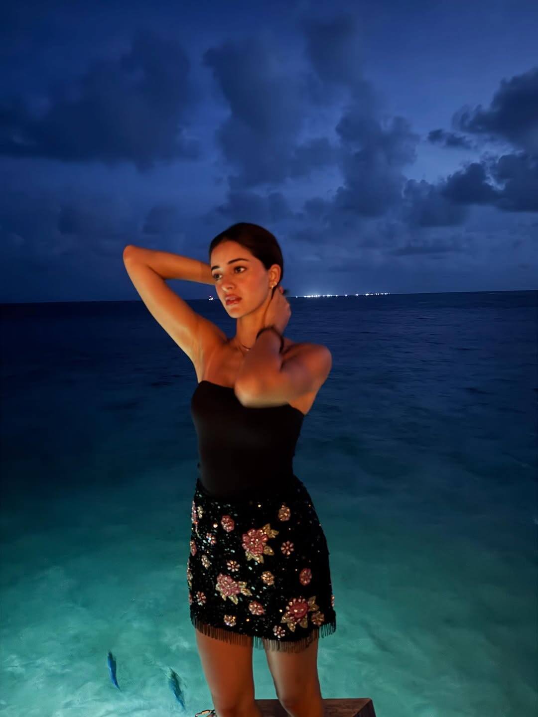 Ananya's glamorous style was captured on camera amidst the night views on the sea shore. His pose in a black dress is enhancing him even more.