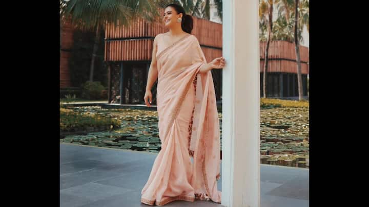 5. ⁠Blush Pink Saree: Kajol embraces soft sophistication in this blush pink saree, adorned with delicate embroidery along the borders. The pastel hue exudes calm elegance, while the subtle embellishments add a refined festive touch. For Durga Puja 2025, this saree is perfect for those who prefer minimal yet elegant festive wear. Kajol completes the look with statement earrings and a sleek ponytail, striking the perfect balance between simplicity and charm. (Image Source: Instagram/@kajol)