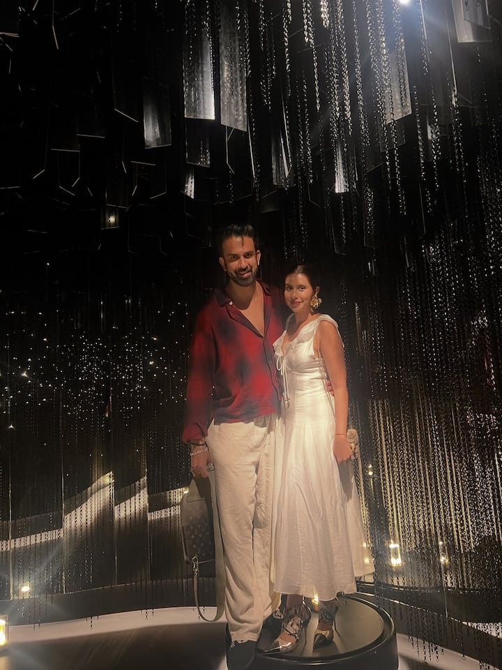 At the same time, Charu is looking very graceful and elegant in white white sleeveless dress. He has completed his look with golden earrings, nude makeup and red lipstick, giving them a simple but glamorous appearance. This date of both of them is creating a night styling classy and perfect couple vibes.