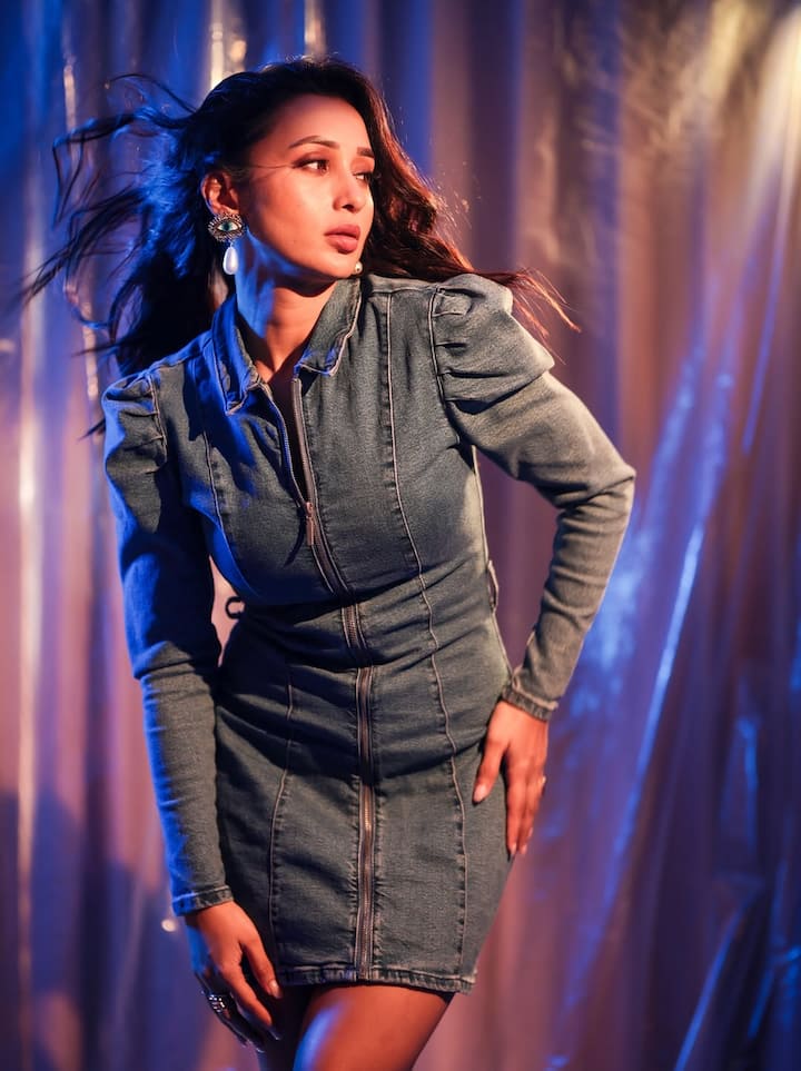 The look of mm in this picture is quite casual-chick. She is wearing full-sleeve denim zipper dress which is giving her a trendy and smart look. Statement earrings and open wavy hair are making their outfits more glamorous.