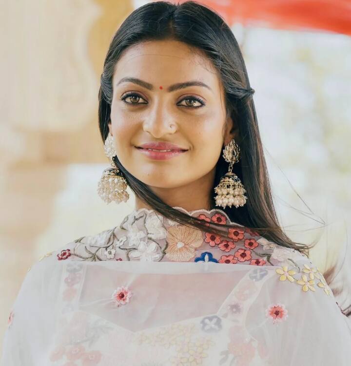 In this picture, Monalisa, wearing big earrings in the ears with a suit, looks very cute.