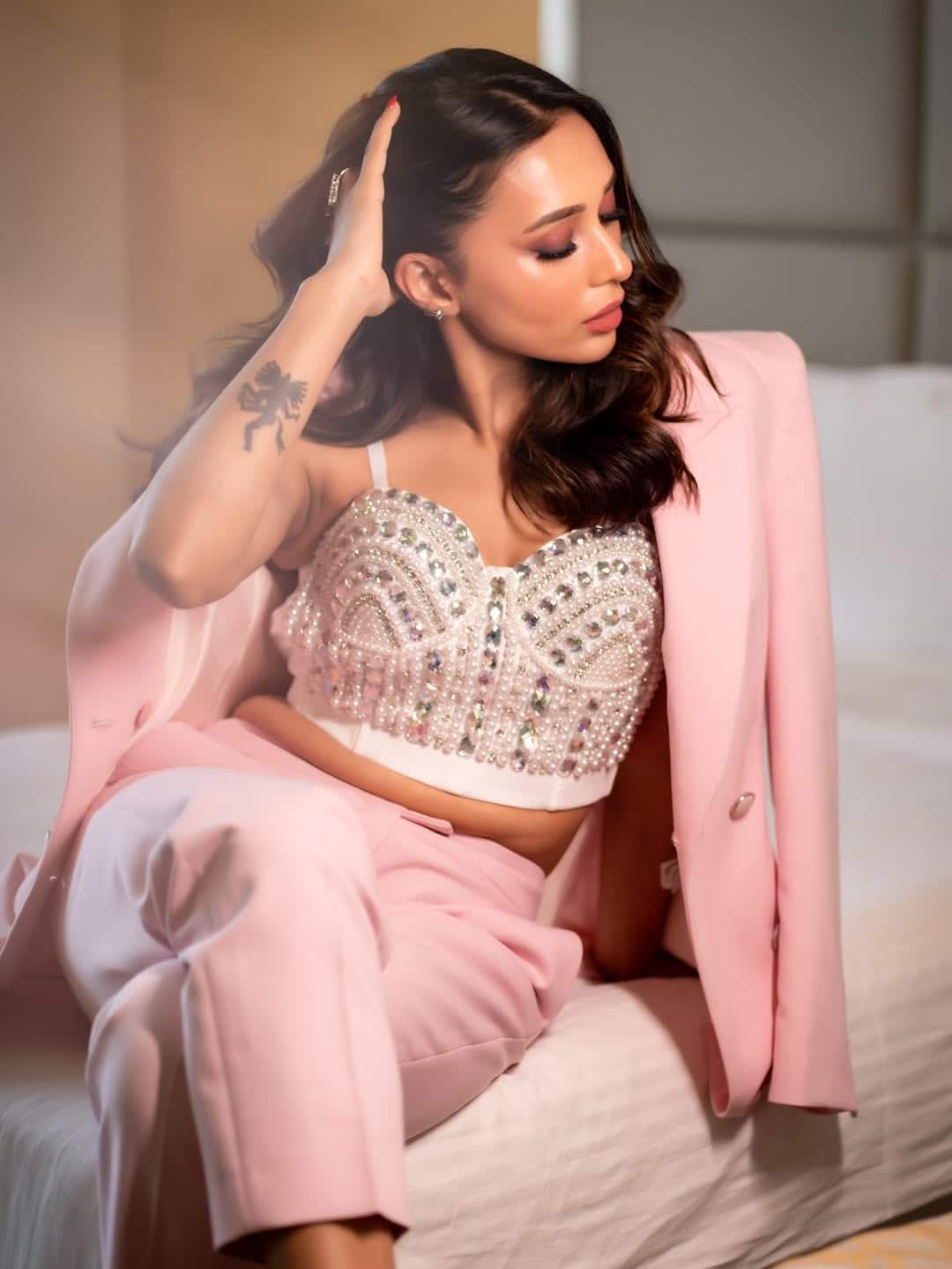 This look of Mm is extremely glamorous and modern. He is wearing a pink pant-suit, which is paired with stylish brlates with stone work. Open wave hair and nude makeup are making this look more elegant.