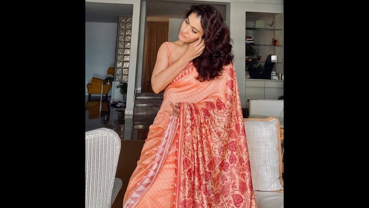 1. Peach Saree With Floral Pallu: Kajol stuns in a peach saree that blends timeless elegance with festive charm. The saree features delicate polka-dot detailing across the drape, giving it a subtle yet sophisticated appeal. The highlight is undoubtedly the contrasting red floral pallu, adorned with intricate patterns. Paired with a sleeveless blouse, this ensemble perfectly balances contemporary styling with classic saree grace. (Image Source: Instagram/@kajol)