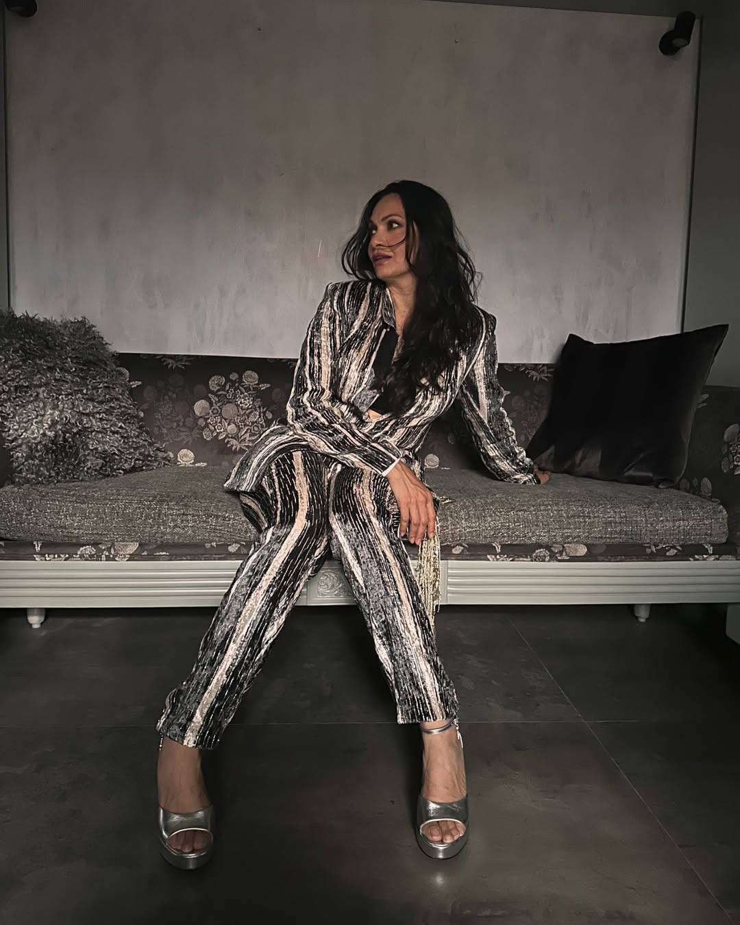 In this picture, Maria is wearing Shiney Black-Goldish Pantsuit. They have carried silver heels with it. Open hair and minimal makeup are balanced by their look. This look of Maria is stylish and glamorous.