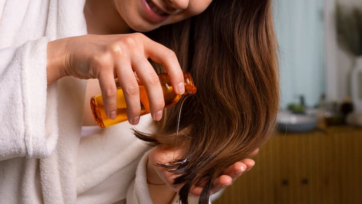 Skipping the Champi: Festive rush often makes us skip the basics. But a traditional oil massage (champi) is still the best therapy. Regular oiling with paraffin-free natural oils strengthens roots, reduces hair fall, and boosts shine. Oils with bhringraj, amla, or coconut is especially effective. (image Source: freepik)