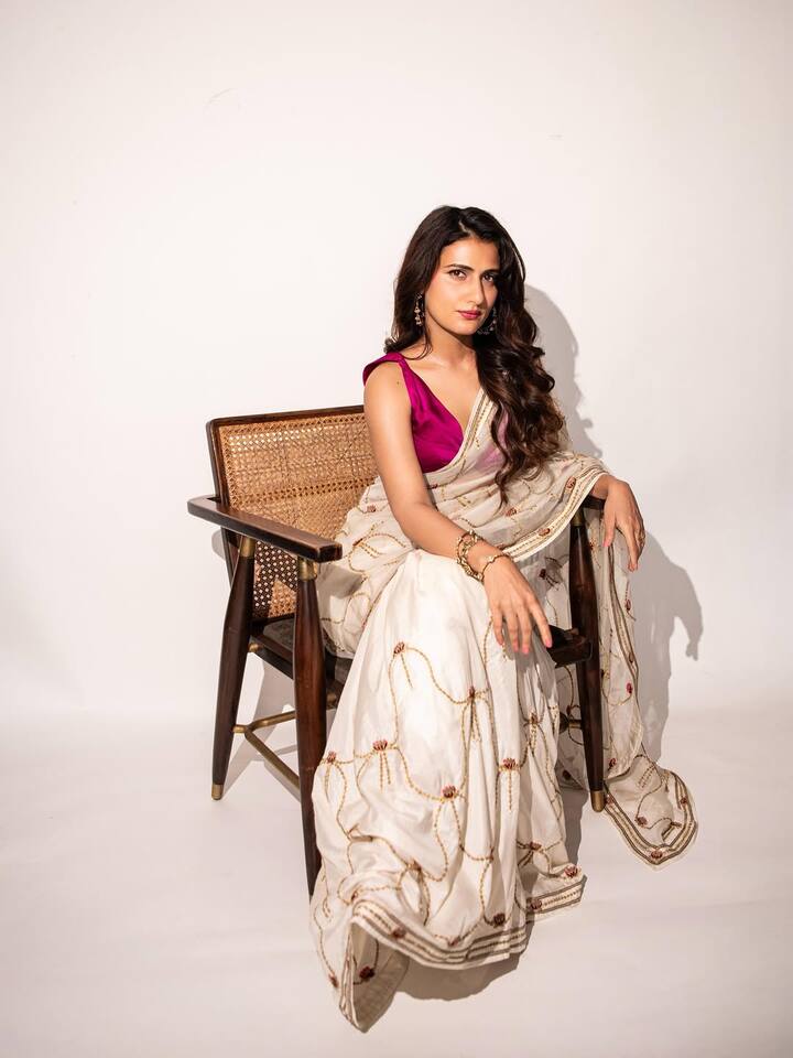 In this traditional look, Fatima is wearing a white sari with a golden and maroon detailing, which she has paired with a magenta blouse. Open wavy hair, minimal jewelery and confident poses are making his look elegant and graceful.