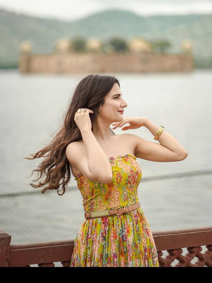 This look of Fatima Sana Sheikh is very fresh and travel vibes. She is wearing a multicolor strapless maxi dress, which is styled with the belt. Open wavy hair and minimal jewelery such as gold bangles and ring.