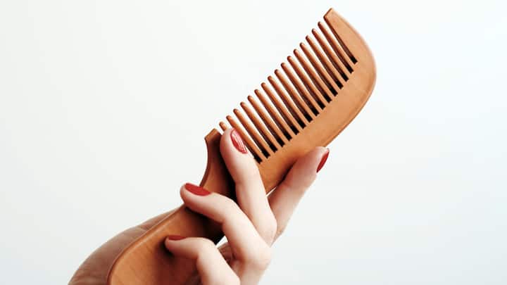 Using the Wrong Comb: Plastic combs can cause breakage and scalp irritation. Switch to neem wood combs; they prevent cuticle damage, stimulate the scalp, and help control dandruff and hair fall naturally. (image Source: Canva)