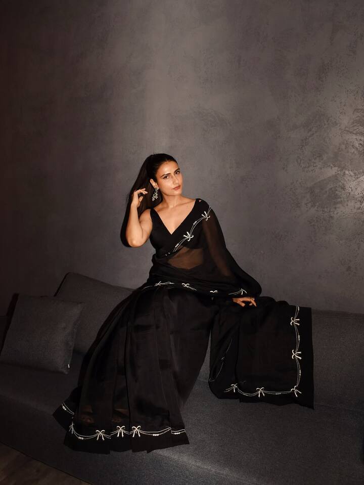 Fatima looks very elegant wearing a black saree in this picture. White border detailing and deep neck blouses on the saree are making their style graceful. His look looks even more classy with high ponytail and statement earrings.