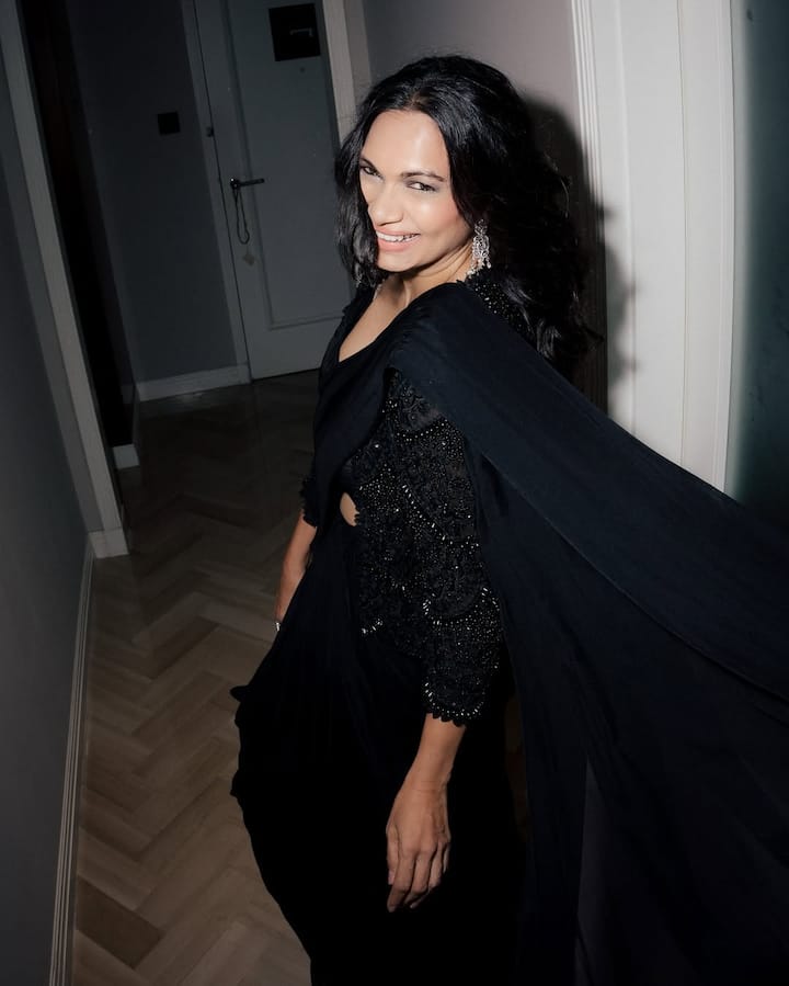 Maria is wearing a stylish gown of black color shimmer detailing in this look. Their open hair and earrings are making the look more graceful. His look is very classy.