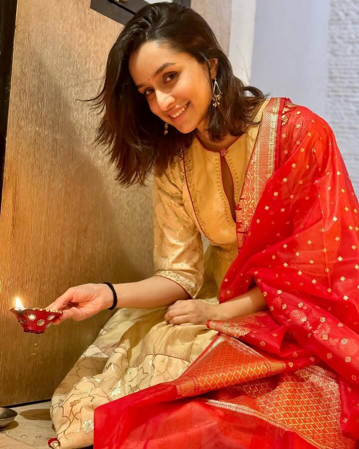 Shraddha Kapoor has adopted a traditional style in this look. He is wearing a golden color suit on which there is light floral work. With this, he has carried a red Banarasi scarf. Simple makeup, open hair and earrings are highlighting their beauty.