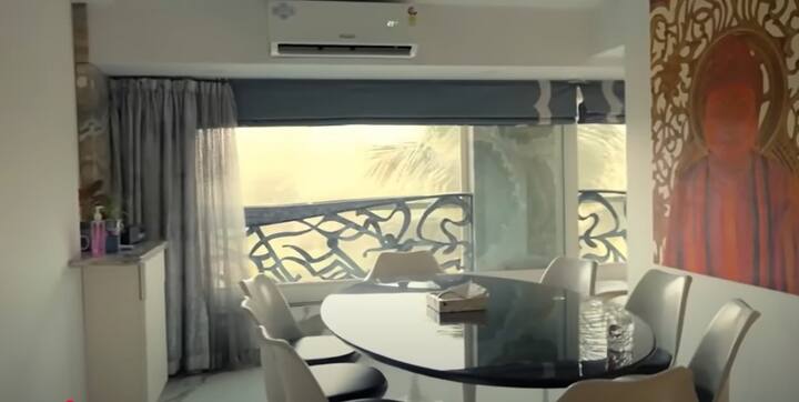 Talking about the dining room of Tamannaah Bhatia's house, the effect of modern art is seen here too. Oval Black Table and White Stealish Chairs make it perfect combination. The light coming from panoramic window, sitting with and eating food, improves the experience of eating.