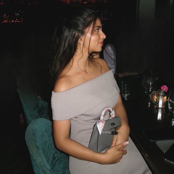 In this picture, Suhana is wearing an off-shoulder gray bodycon dress, which is giving her a very chick and elegant look. With minimal jewelery, natural makeup and ponytail hairstyle, he has carried it in a sutle but glamorous manner.