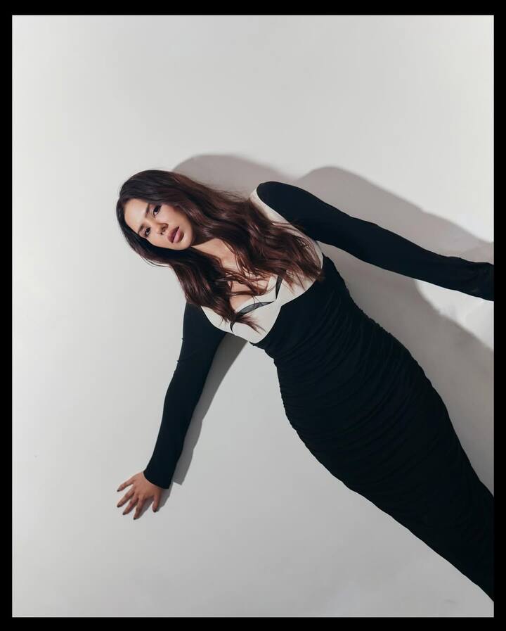 Sonam's look in this picture is very classy and elegant. She is seen wearing a bodicon dress with black-and-white contrast, which has deep neckline and full sleeves. Their open wavy hair and nude makeup are making this look even more glamorous.