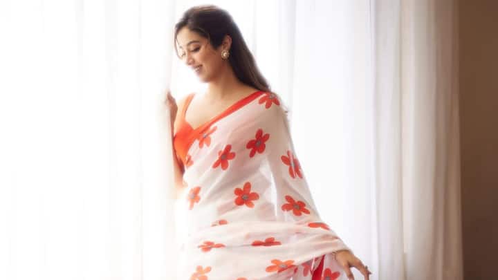 Day 1 – White: Janhvi stunned in this chiffon saree adorned with delicate red floral motifs. The plunging neckline blouse with tie-up detailing at the back added a modern twist, while her bold eyes and minimal glam kept the look chic yet festive. (Image Source: Instagram/ janhvikapoor)