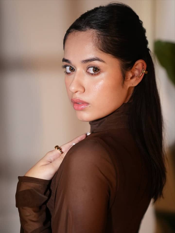 Her hair was styled sleek and straight, parted in the middle and tucked neatly behind her ears, adding to the polished, refined vibe of the ensemble.