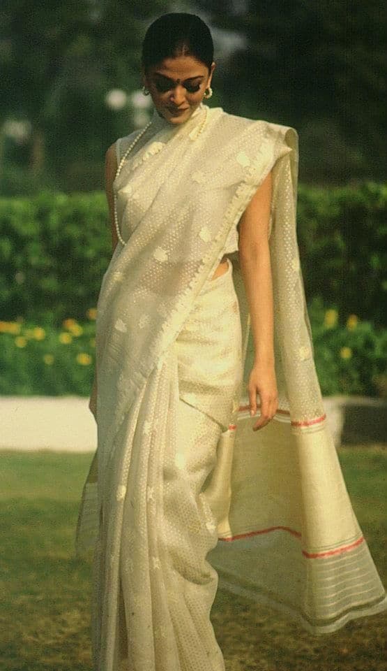 In this picture, Aishwarya is wearing a very light and beautiful saree of white colored. This saree is sheer and small white dots have been worked on it. She is wearing a sleeveless blouse with this saree. He has completed this look with pearl's long necklace and matching earrings.
