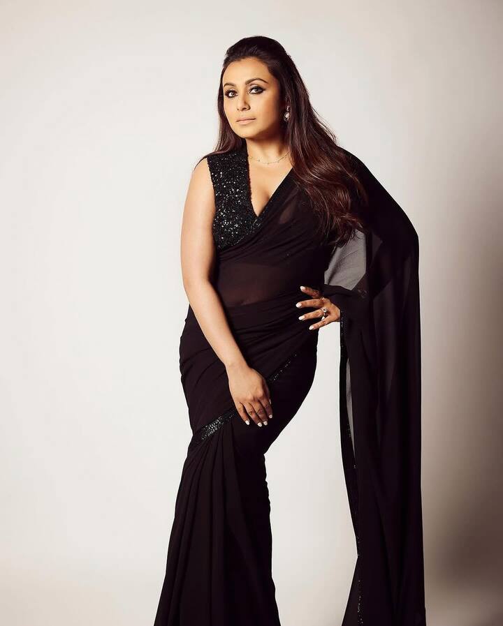 इस तस्वीर में रानी ब्लैक कलर की साड़ी के नजर आ रहीं हैं. उन्होंने स्लीवलेस ब्लाउस कैरी किया है जो लुक को और भी मॉडर्न बना रहा है. सिंपल नेकलेस और खुले बालों के साथ उन्होंने लुक को कंप्लीट किया.