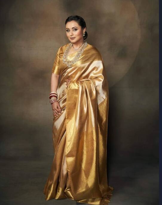 In this picture, Rani is seen in a sari with Golden and White Combination. By making heavy necklace and bun, he gave this look to a royal touch.