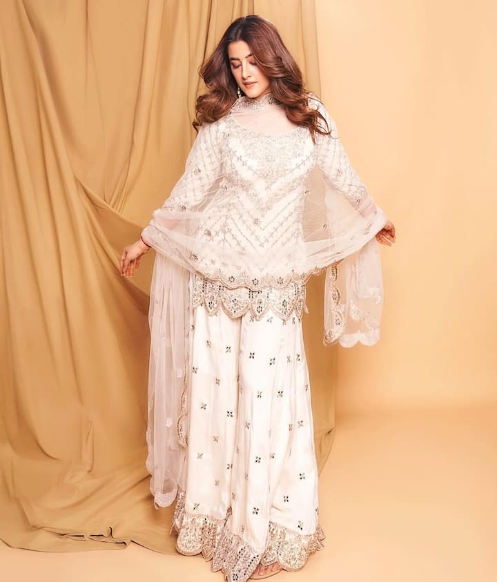 In this picture, Nupur is wearing a very beautiful white sharara suit. Silver colored embroidery has been done on their suit, giving it a classy and elegant look. He has taken a light scarf with his suit. Nupur has kept his hair open and his makeup is also very light and natural, due to which his entire look looks quite simple and sobber.