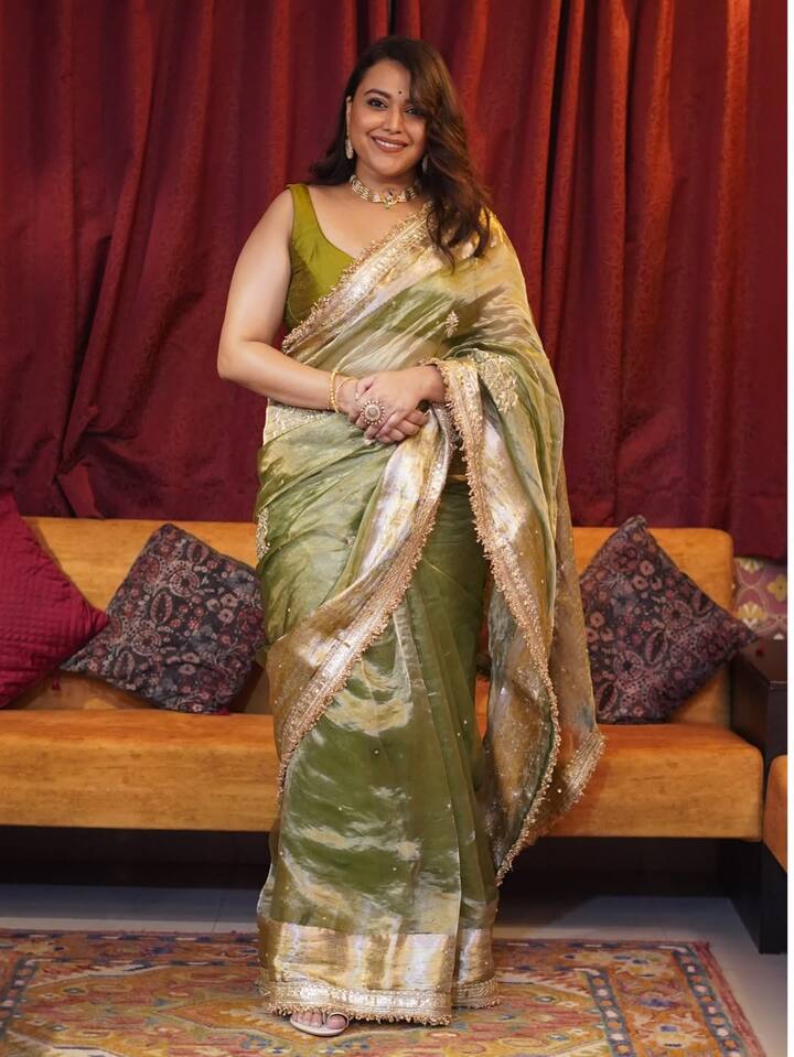 स्वरा ने इस लुक मे एक खूबसूरत हरे रंग की साड़ी पहनी है, जो गोल्डन बॉर्डर के साथ है. यह साड़ी सिल्क जैसे हल्के फैब्रिक की है. उन्होंने इसके साथ मैचिंग हरे रंग का स्लीवलेस ब्लाउज पहना है. ज्वैलरी में उन्होंने एक चोकर नेकलेस, मैचिंग झुमके और कुछ रिंग पहना हैं. उनके बाल खुले हैं और उन्होंने मेकअप भी मिनिमल रखा है.
