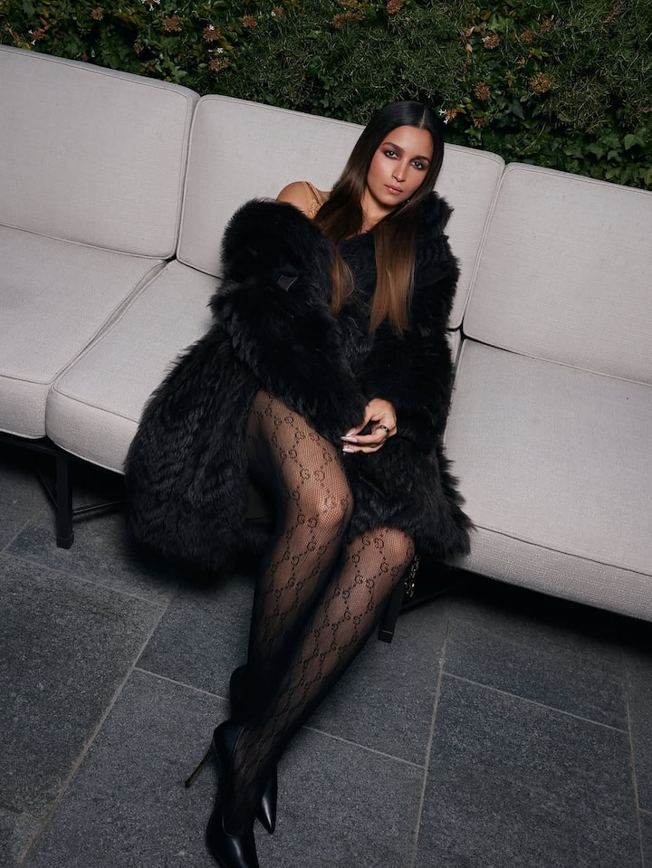 Her sleek long hair, smokey eyes, and a statement purse added to the powerful high-fashion vibe.