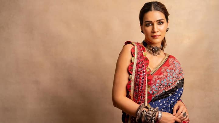 Kriti wore this royal blue saree with contrasting red and pink borders. She styled it with a sleeveless blouse and chunky jewels, including a bold choker and bangles. (Image Source: Instagram/ kritisnanon)