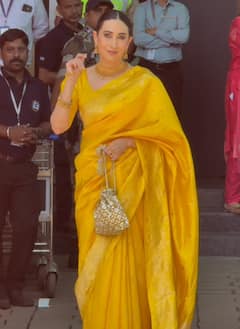 येलो साड़ी...बालों में गजरा, एयरपोर्ट पर दिखा करिश्मा कपूर का खूबसूरत अवतार, तस्वीरें वायरल