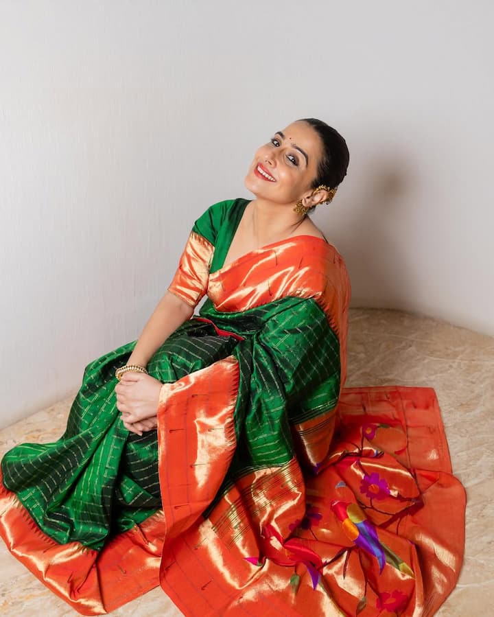 विद्या बालन इन तस्वीरों मे बेहद ही खूबसूरत और ट्रेडिशनल लुक में नजर आ रही हैं. उन्होंने हरे और नारंगी रंग की सिल्क की साड़ी पहनी है जो बहुत ही शानदार लग रही है. साड़ी का गहरा हरा रंग और नारंगी रंग का पल्लू और बॉर्डर एक बेहतरीन कंट्रास्ट बना रहा है.