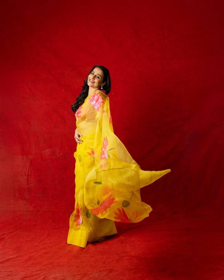 चौथे दिन (पीला)- विद्या ने हल्के पीले रंग की फ्लोरल ऑर्गेंजा साड़ी पहनी जिस पर गुलाबी कमल के प्रिंट थे, जो खुशी और पॉजिटिविटी का प्रतीक है.