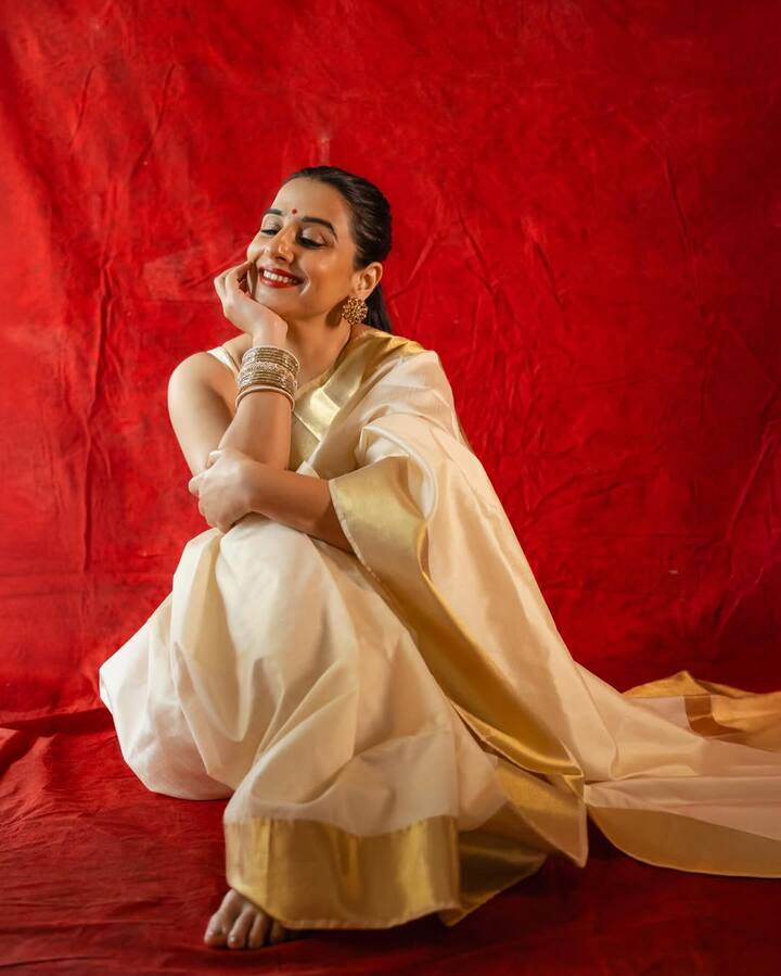 पहले दिन (सफेद)- विद्या ने केरल की पारंपरिक कासवु साड़ी पहनी थी जिसका रंग हल्का सफेद और गोल्डन था. यह सिंपलीसिटी और प्योरिटी को दिखाता है.