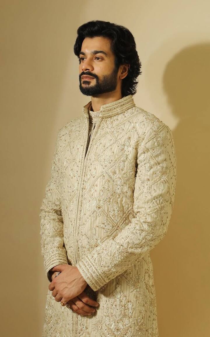 Ivory Sherwani Perfection : Sunny turned heads in a stunning ivory sherwani adorned with delicate embellishments—perfect for wedding festivities. Styled with cream trousers and a subtle ring, the outfit exuded refined charm.