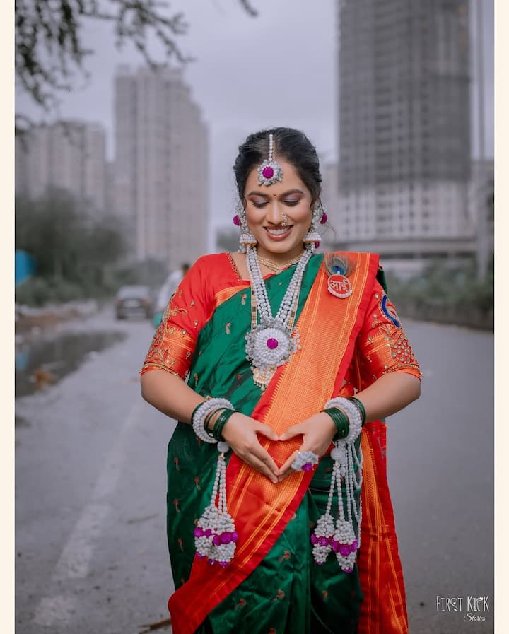 इन तस्वीरों में मॉम टू बी सयाली मराठी लुक में नजर आ रही हैं. उन्होंने रेड और ग्रीन कॉम्बिनेशन की साड़ी पहनी है. साथ सिंगर ने हैवी ज्वेलरी कैरी की.