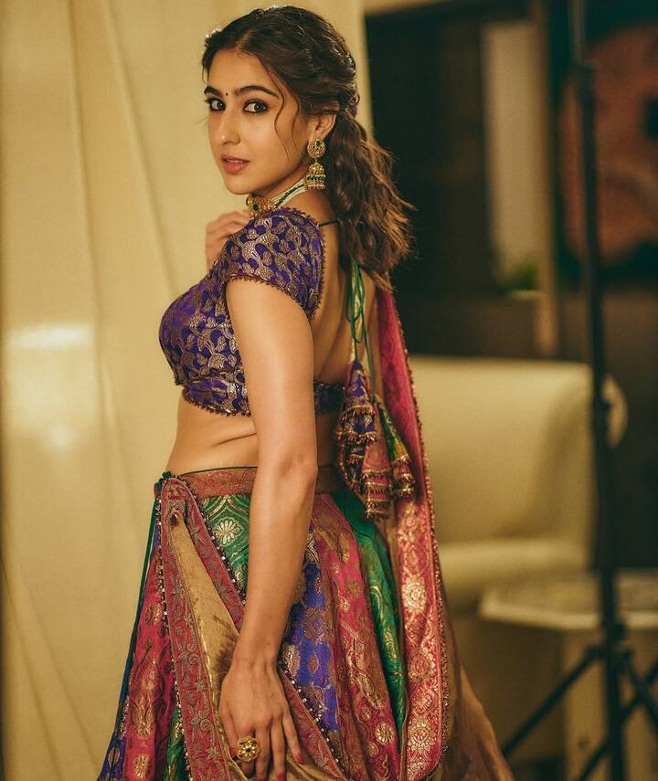 In this style, Sara Ali Khan has been taken from the middle, by twisting a slight twist of the front and by putting a pin. All the rest of the hair is collected and a wavy ponytail is made at the height. This half-up half-down style looks very youthful with their multicolored lehenga and traditional earrings.