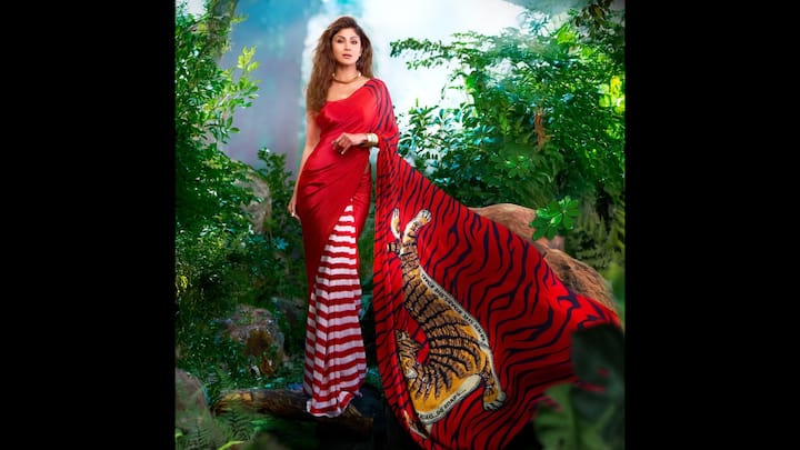7. ⁠Shilpa Shetty: This look is a masterclass in modern festive wear. Shilpa's saree features a striking combination of red and white stripesdominating the drape. This graphic, bold print is a contemporary twist on the traditional single-colour red worn for the ritual. The bold pallu of the saree symbolises rength and grace, making it a powerful choice for the day dedicated to a husband's well-being. She pairs the saree with a sleek, minimalist blouse. This look is for the confident, modern woman. It keeps the essential auspicious red but infuses it with a daring, unforgettable print. (Image Source: Instagram/@theshilpashetty)