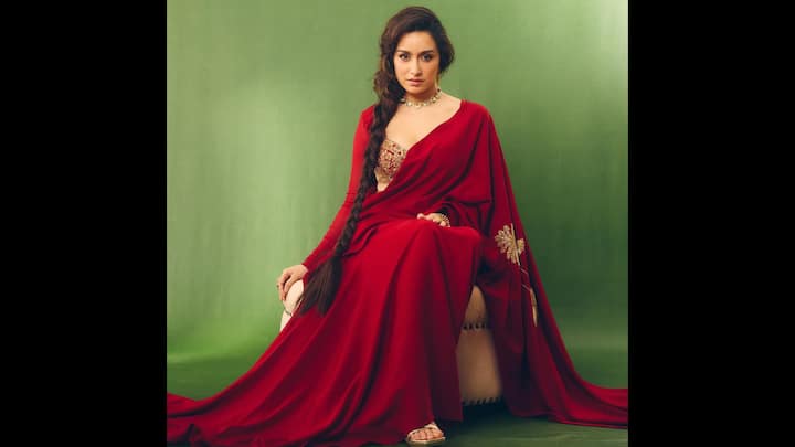 4. ⁠Shraddha Kapoor: Draped in a deep crimson saree with intricate golden embroidery on the pallu, Shraddha Kapoor perfectly balances tradition with glamour. What makes her look stand out is the way she paired it with a stunning embroidered blouse, which added a hint of modern charm to the festive ensemble. Her long braid adorned with soft waves and a statement chokan necklace elevates the look, making it ideal for women who want to keep their Karwa Chauth attire graceful yet impactful. The flowing silhouette of the saree gives it a regal touch. This Shraddha Kapoor saree look is proof that you can embrace ethnic traditions while keeping your festive style effortlessly chic. (Image Source: Instagram/@shraddhakapoor)